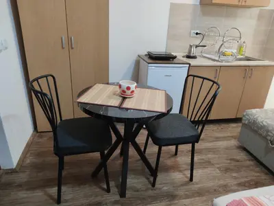 a small table with two chairs and a mug on it at Studio Elizabeta in Soko Banja
