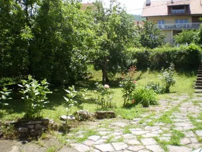 a garden with plants and trees and a building at Studio Elizabeta in Soko Banja