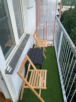 two chairs and a table on a balcony at Comfy Studio - 1 minute walk to Delta Planet in Niš