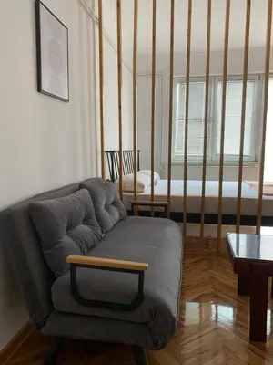 a living room with a couch and a bed at Comfy Studio - 1 minute walk to Delta Planet in Niš