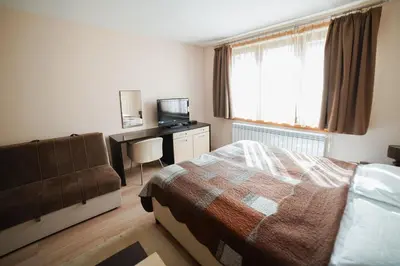 a bedroom with a bed and a desk and a television at Studio Unna in Kopaonik