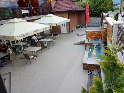 an outdoor patio with tables and chairs and umbrellas at Kompleks Fontana in Vladičin Han