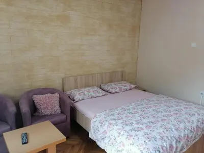 a small bedroom with a bed and a couch at Apartmani Milosavljevic in Soko Banja