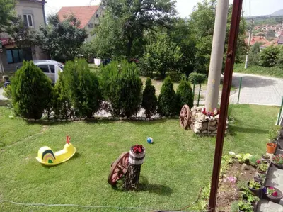 a yard with a toy house and a playground at Apartmani Milosavljevic in Soko Banja