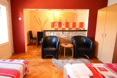 a living room with two chairs and a kitchen at Apartmani Milosavljevic in Soko Banja