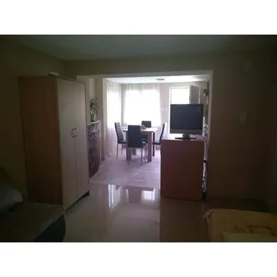 a living room with a television and a table with chairs at Apartmani Milosavljevic in Soko Banja