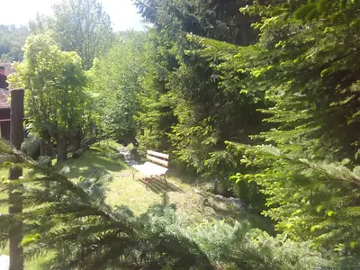 a bench in the middle of a garden with trees at Vikend kuca Bela Reka in Brzeće