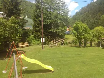 a playground with a yellow slide in a field at Vikend kuca Bela Reka in Brzeće