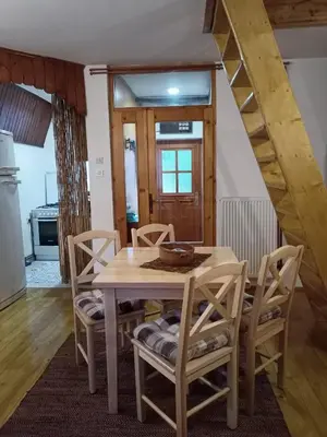 a dining room with a wooden table and chairs at Vikend kuca Bela Reka in Brzeće