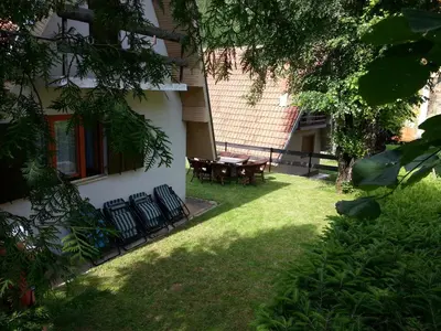 a yard with chairs and a table in front of a building at Vikend kuca Bela Reka in Brzeće