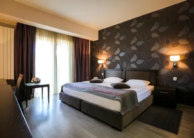 a hotel room with a bed and a large window at Hotel Stara Planina in Ćuštica