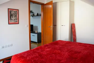 a bedroom with a red blanket on a bed at Zafir 1 in Vrnjačka Banja