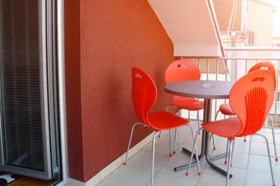 a table and orange chairs in a room at Zafir 1 in Vrnjačka Banja