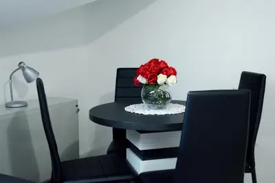 a table with a vase of flowers on top of books at Zafir 1 in Vrnjačka Banja
