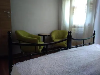 two green chairs and a bed in a bedroom at Garmani in Vrnjačka Banja