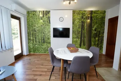 a dining room with a white table and chairs at ŽUPAN apartmani in Soko Banja