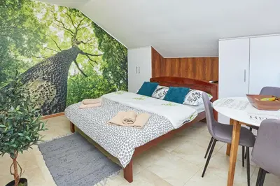 a bedroom with a bed and a table and a mural at ŽUPAN apartmani in Soko Banja