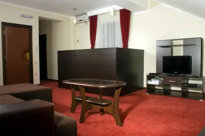 a living room with a table and a television at Vila Prica in Niška Banja