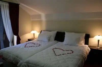 a bedroom with a bed with hearts written on it at Vila Prica in Niška Banja