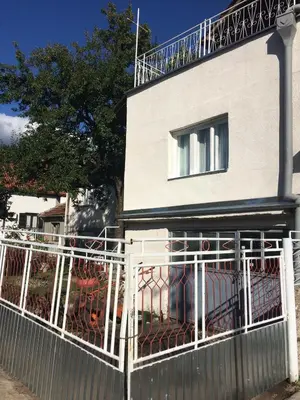 a white fence in front of a house at Sobe SANjA in Pirot