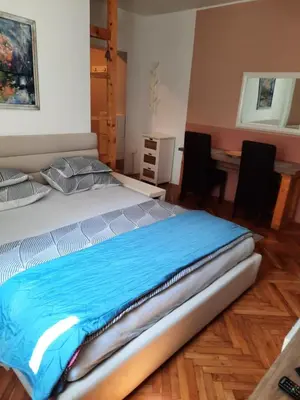 a large bed in a room with a table at Apartmani Biljana Lazić in Vrnjačka Banja