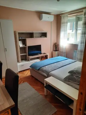 a bedroom with a bed and a desk and a television at Apartmani Biljana Lazić in Vrnjačka Banja