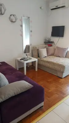 a living room with a couch and a table at App Milica do akva parka Raj in Vrnjačka Banja