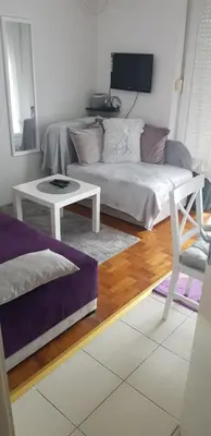 a living room with a couch and a table at App Milica do akva parka Raj in Vrnjačka Banja