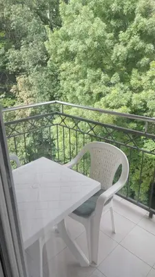 a white table and chairs on a balcony at App Milica do akva parka Raj in Vrnjačka Banja