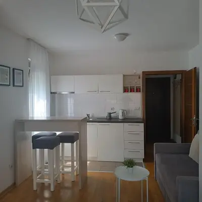 a kitchen with a counter and stools in a room at Apartments Karamarković in Vrnjačka Banja