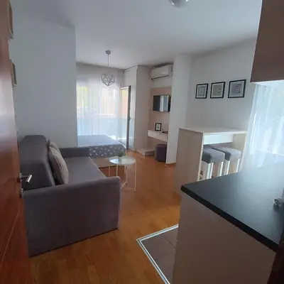 a living room with a couch and a room with a bed at Apartments Karamarković in Vrnjačka Banja