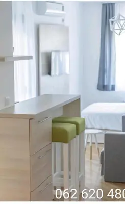 a kitchen with a desk with a green stool at Apartments Karamarković in Vrnjačka Banja