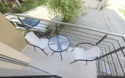 three chairs and a table on a balcony at Apartments Karamarković in Vrnjačka Banja