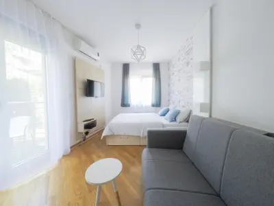 a living room with a couch and a bed at Apartments Karamarković in Vrnjačka Banja