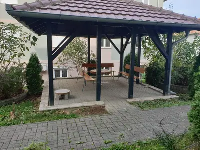 a wooden gazebo with a bench and a table at Studio Dunja in Vrnjačka Banja