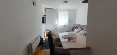 a living room with a table and a couch at Studio Dunja in Vrnjačka Banja