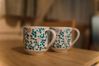 two coffee cups sitting on top of a wooden table at Boni M in Kopaonik