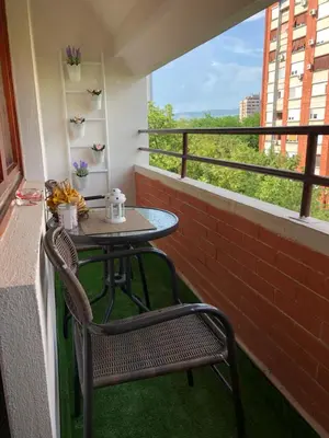 a small table and chairs on a balcony with a window at Leo in Niš