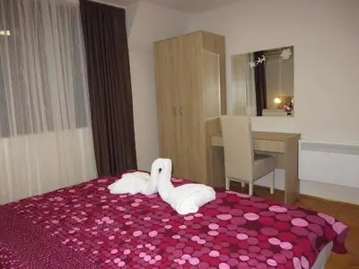 a bedroom with two towels on a bed with a pink sheet at Leo in Niš