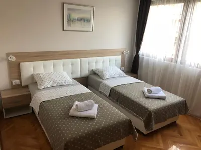 two beds in a room with towels on them at Leo in Niš