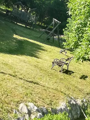 a park bench sitting in the grass in a field at Apartman 