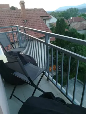 a chair sitting on the balcony of a house at Apartman 