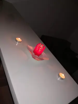 a red object sitting on a white table with two lights at Apartman 