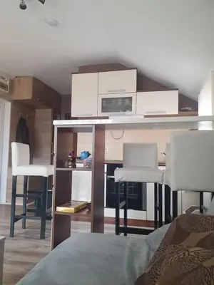 a room with a kitchen with a table and chairs at Apartman 