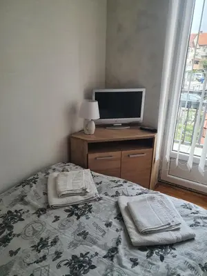 a bedroom with a bed and a television on a desk at Apartman 