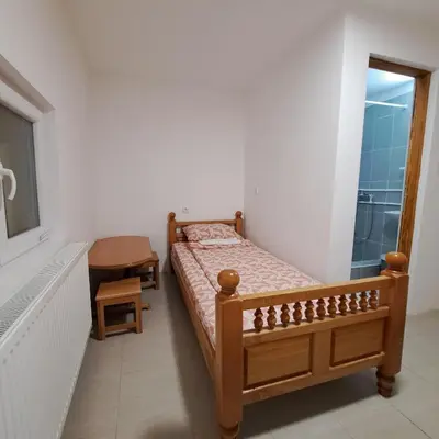 a bedroom with a bed and a desk and a window at STD 