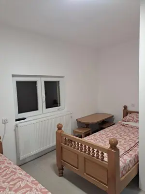 a bedroom with two beds and a table and a window at STD 