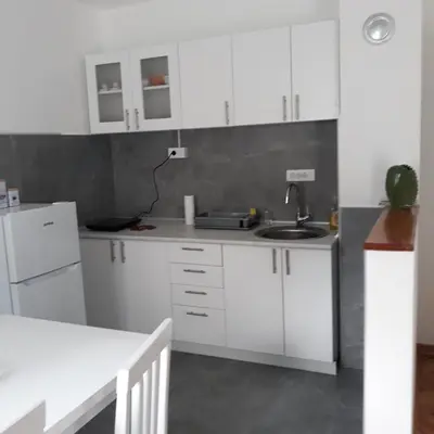 a kitchen with white cabinets and a sink at Apartment Holiday in Vrnjačka Banja