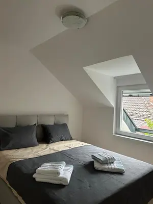 a bedroom with a bed with two towels on it at Apartment Holiday in Vrnjačka Banja