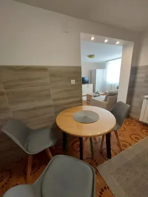 a room with a table and chairs and a couch at Apartment Holiday in Vrnjačka Banja